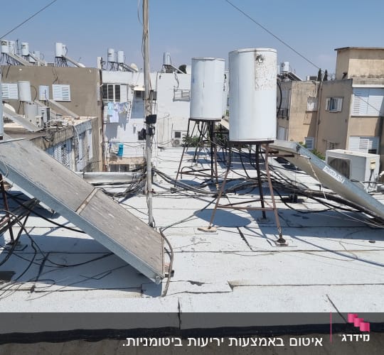 גג עם יריעות איטום, דודי שמש וצינורות חשמל